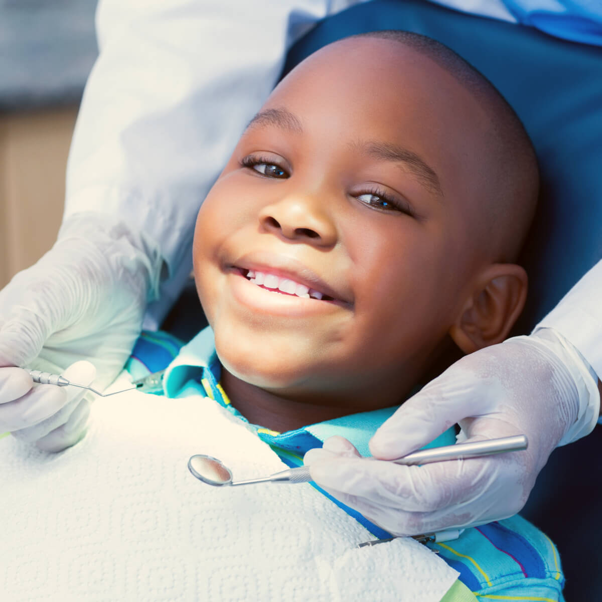 A smiling boy getting his teeth cleaned at the dentist's